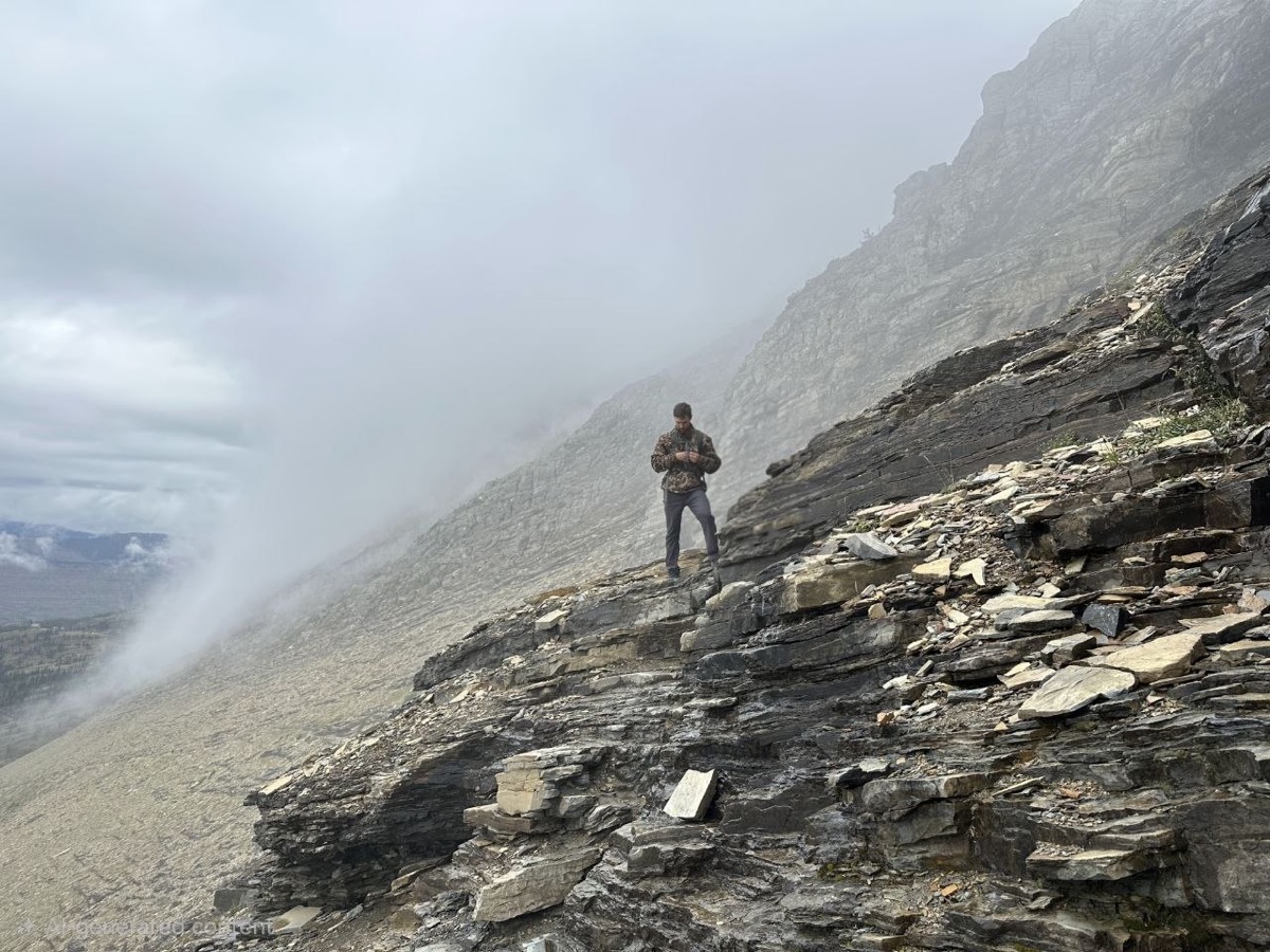 Wearing the Drake Lightweight Packable Jacket on an exposed, fog-covered ridge in Glacier National Park