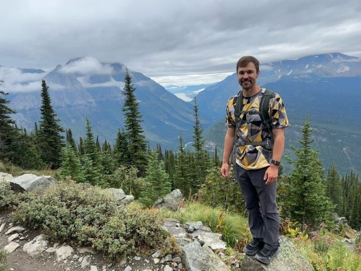 Wearing the PackLite Life Gold Geometric Jersey on the Highline Trail with a valley view behind