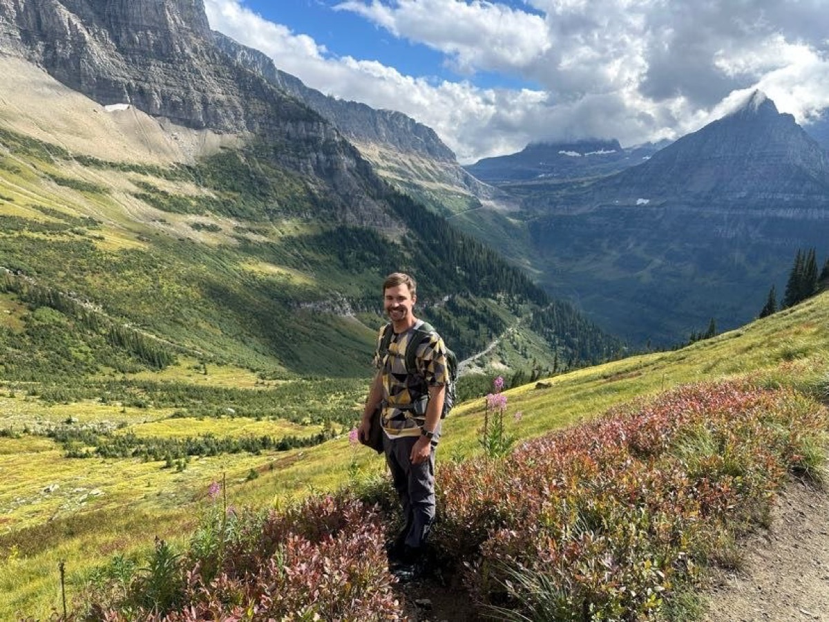 Standing on the Highline Trail with wildflowers and a wide mountain valley view