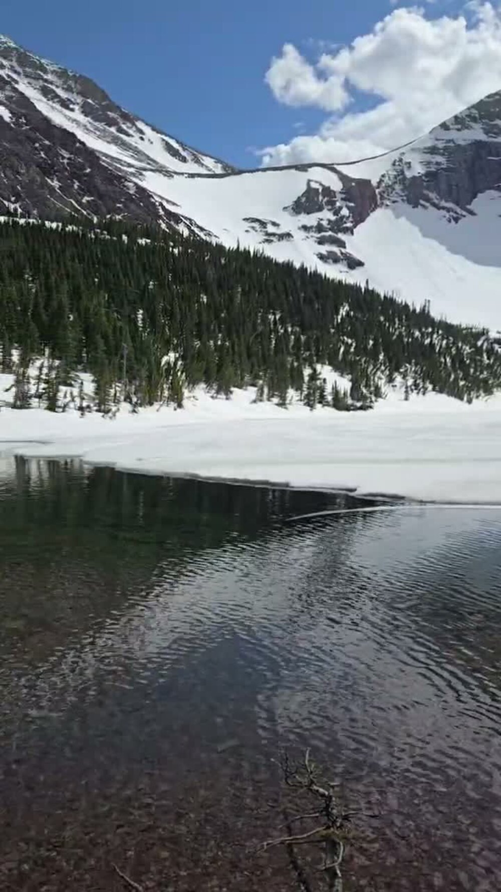 Otokomi Lake still mostly frozen over in late May, below a snow-covered Goat Mountain.