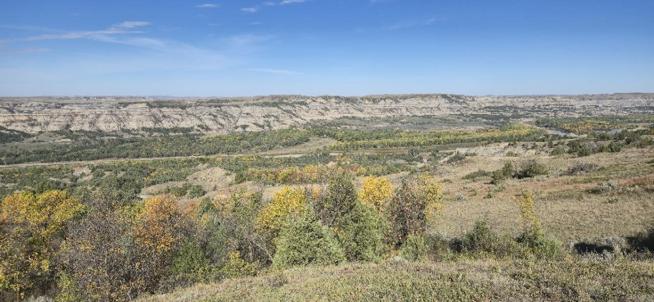 A wide view of the badlands and river valley with early fall color along the South Achenbach Trail.