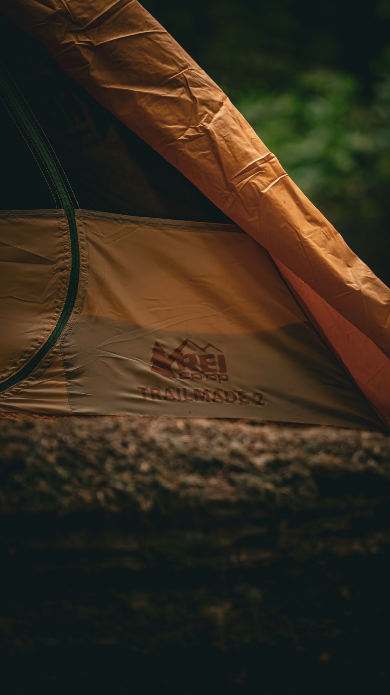 Close-up of the REI Co-op Trailmade 2 tent&rsquo;s rainfly and branding in forest light